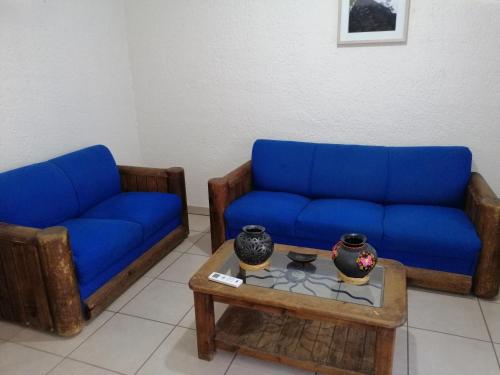 a living room with two blue couches and a coffee table at Departamento la crucecita, con aire acondicionado, excelente ubicación, en segunda planta in Santa Cruz Huatulco