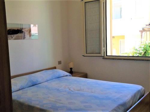 1 cama en un dormitorio con ventana en Casa Vacanze La Bandera 1, en Santa Teresa Gallura