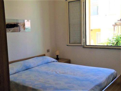 サンタ・テレーザ・ガッルーラにあるCasa Vacanze La Bandera 1の窓付きのベッドルームのベッド1台