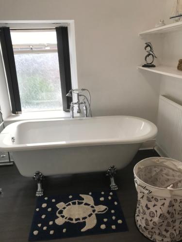 a white bath tub in a bathroom with a window at Heulwen in Barmouth