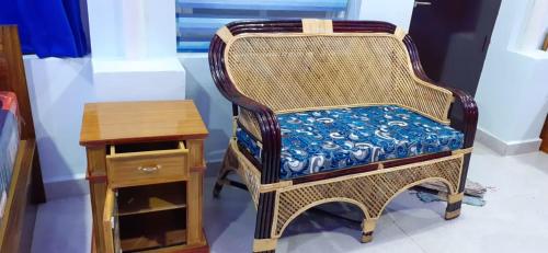 a wicker chair sitting next to a wooden table at Elim luxury suite in Tarangambādi