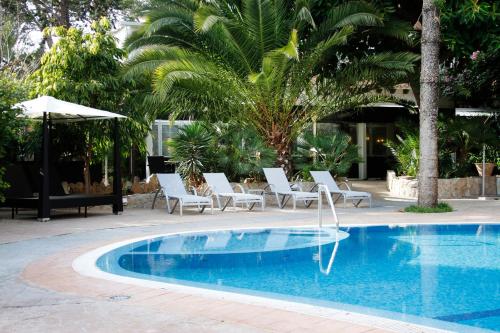 a swimming pool with lounge chairs and a swimming pool at Morlans Garden in Paguera