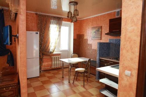 a kitchen with a table and a white refrigerator at Apartment in Lipetsk in Lipetsk