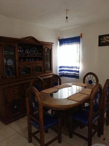 a dining room with a wooden table and chairs at Departamento la crucecita, con aire acondicionado, excelente ubicación, en segunda planta in Santa Cruz Huatulco