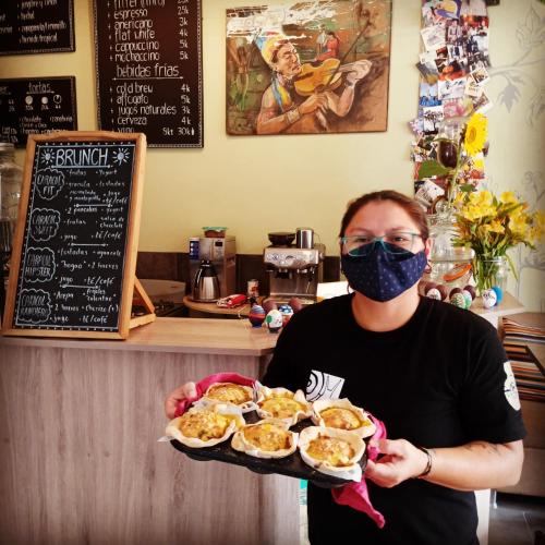 a man wearing a mask holding a plate of food at El Caracol in Popayan