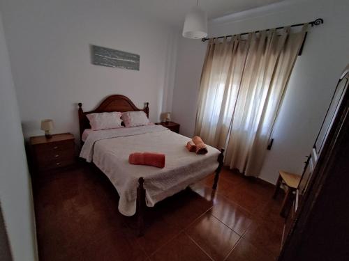a bedroom with a bed with two pillows on it at Apartamento Rosa in Porto Covo