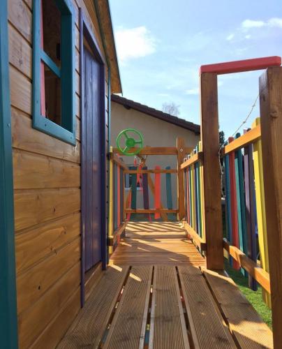 a wooden deck with a playground on the side of a building at GardenLux Vrdnik in Vrdnik