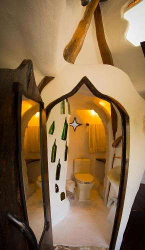 ein Badezimmer mit Toilette und Spiegel in der Unterkunft La Quinta Orquídea in Puerto Morelos