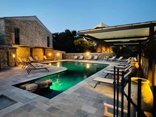 a swimming pool with lounge chairs next to a building at Hôtel Casa Rossa & Spa in LʼÎle-Rousse