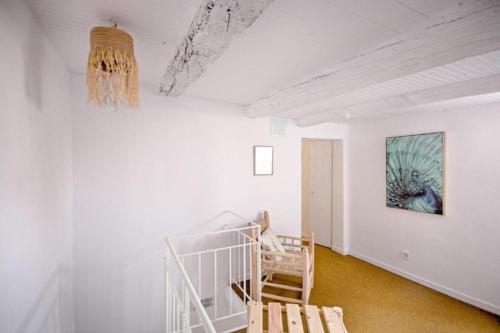 a white room with a staircase and a painting on the wall at Old Charming Faro Apartment in Faro