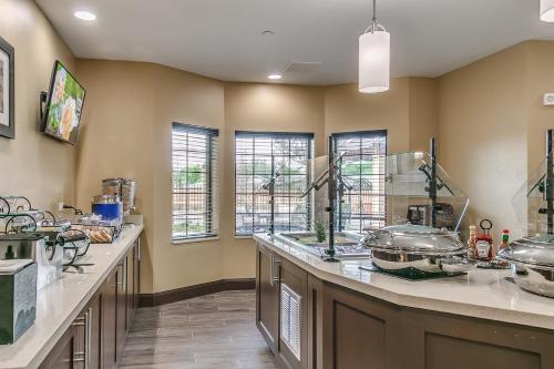 a large kitchen with a counter with many dishes at Staybridge Suites Lubbock South by IHG in Lubbock