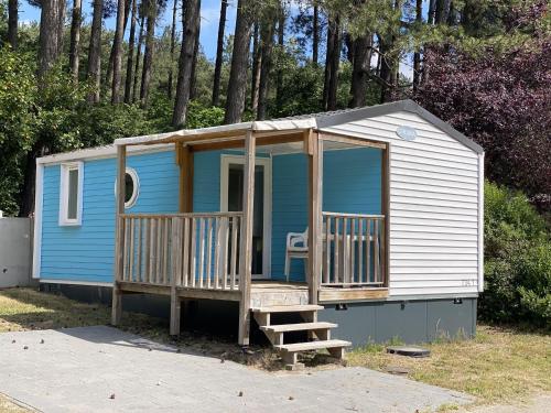 een blauw en wit tiny house met een veranda bij Neat chalet with microwave Antwerp at 39 km in Rijkevorsel