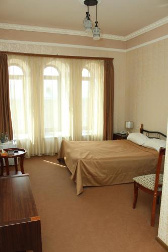 a bedroom with a large bed and windows at Golden Apricot in Gyumri