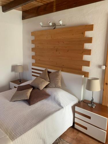 una camera con letto bianco e testiera in legno di Fajazinha Cottage a Faja Grande