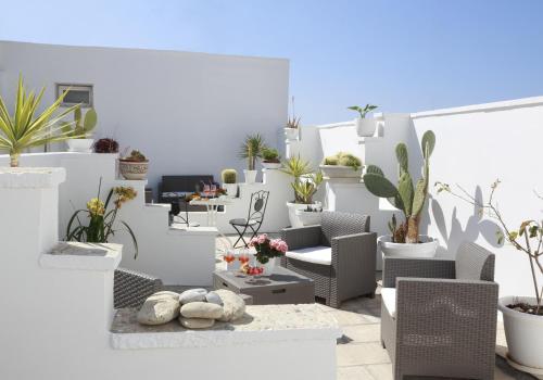 a white room filled with lots of plants at Palazzo Stapane in Santa Maria al Bagno