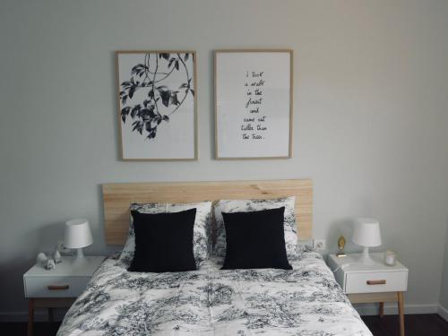 sypialnia z łóżkiem z dwoma lampami i dwoma obrazami na ścianie w obiekcie Atico Berrocal Marbella w Marbelli