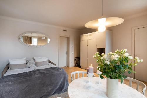a room with a bed and a table with a vase of flowers at Redstone Apartments in Rīga