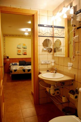 a bathroom with a sink and a room with a bed at Hotel Casa Domenc in Aren