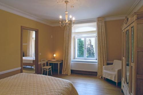 um quarto com uma cama, uma janela e uma secretária em Hostellerie La Maison de Maître em Arbrefontaine