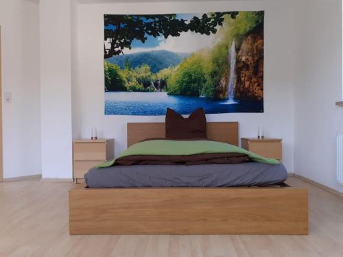 a bedroom with a bed with a painting on the wall at Gesundheits- und Wohlfühlzentrum Matz in Sulzdorf an der Lederhecke