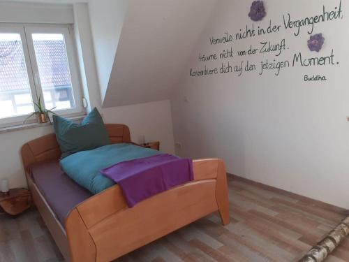 a bedroom with a bed with a quote on the wall at Gästehaus zum Gesundheitszentrum Matz in Sulzdorf an der Lederhecke