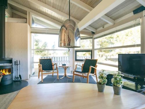 uma sala de estar com uma mesa e uma lareira em 8 person holiday home in Bindslev em Bindslev