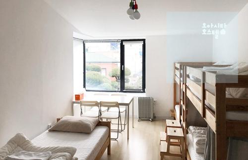 a room with a bed and a table and chairs at Oasita Hostel in Gwangju