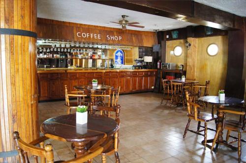 a restaurant with tables and chairs and a coffee shop at Cabo Tortuga Hotel Boutique in Cabo San Lucas