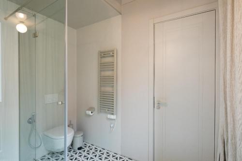 a bathroom with a toilet and a glass shower at Redstone Apartments in Rīga