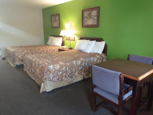 a hotel room with two beds and a table at America's Best Value Inn Clarksdale in Clarksdale