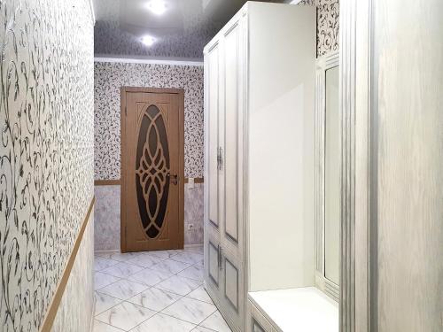 a bathroom with a door and a tiled hallway at Lux Apartament Dacha in Kharkiv