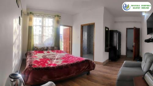 a bedroom with a bed with a red blanket on it at MANNA INSPIRA in Shillong