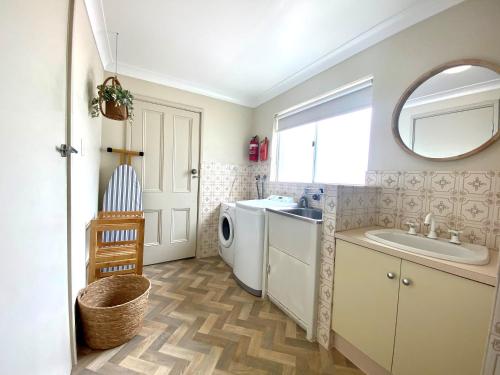 a bathroom with a washing machine and a sink at Clifton Motel & Grittleton Lodge in Bunbury