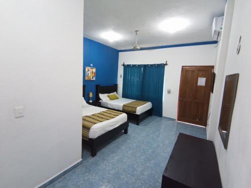 una camera d'albergo con due letti e pareti blu di Posada Antonia Bacalar a Bacalar