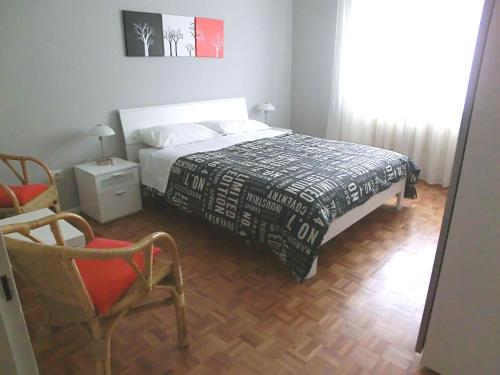 una camera da letto con un letto e una sedia di Le Rose a Trieste