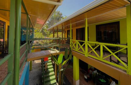 a house with green and yellow walls and a balcony at Hotel El Icaco Tortuguero in Tortuguero