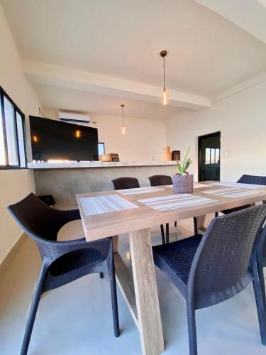 a dining room with a wooden table and chairs at Paradise Surf Hotel in San Miguel