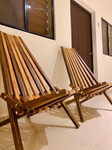 a wooden rocking chair sitting in front of a door at Paradise Surf Hotel in San Miguel