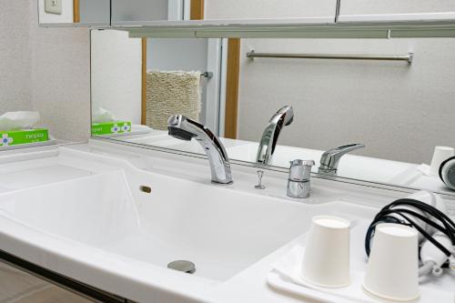 lavabo con 2 grifos y espejo en Gairoju / Vacation STAY 2561, en Higashiōsaka