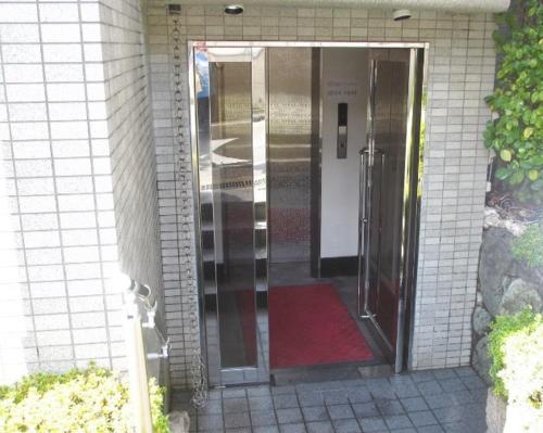 a glass door leading into a building with a red rug at Gairoju / Vacation STAY 2561 in Higashi-osaka