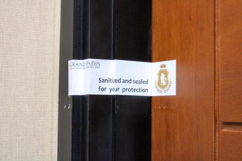 Bondowoso的住宿－Grand Padis Hotel，门上的标志,上面写着,盖上封条,以保护你