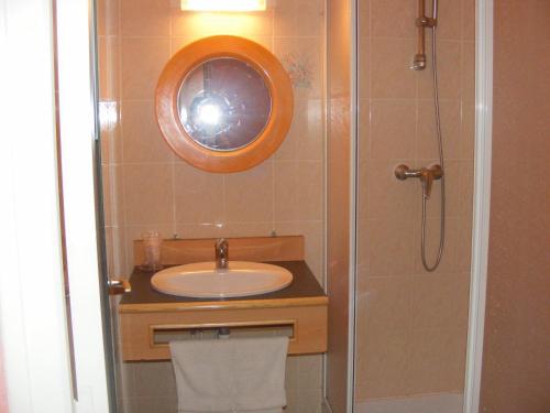 a bathroom with a sink and a shower with a mirror at Le Trianon in Hesdin