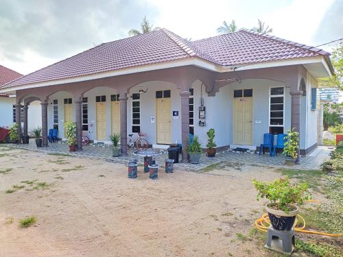ein kleines Haus mit gelben Türen und einer Terrasse in der Unterkunft Desa Besut Inn in Kampung Kuala Besut