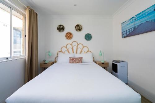 1 dormitorio con cama blanca y ventana en Manly Beachfront Apartment en Sídney