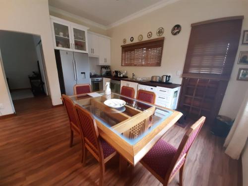 a kitchen with a dining room table and chairs at Rondeletia Cottage Guesthouse - premium self catering in Gillitts