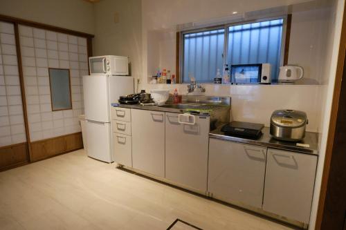 a kitchen with white appliances and a white refrigerator at 一棟貸自炊可-CosyNest-世界遺産 熊野古道歩きの拠点-無料Wi-Fi-駐車場2台無料 in Nachikatsuura
