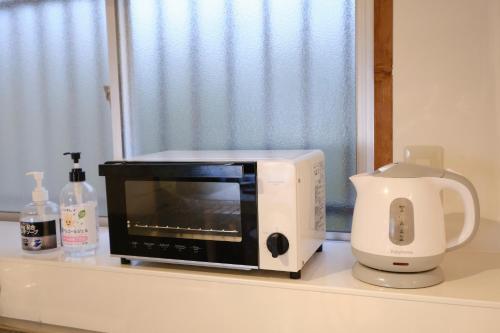 a microwave oven sitting on a counter next to a mixer at 一棟貸自炊可-CosyNest-世界遺産 熊野古道歩きの拠点-無料Wi-Fi-駐車場2台無料 in Nachikatsuura