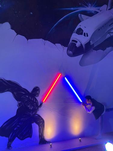 a painting of a man holding a lightsaber and a plane at Space Hotel @ Chinatown Kuala Lumpur in Kuala Lumpur
