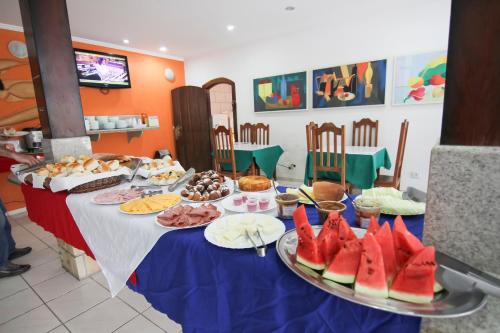 een tafel met borden eten en fruit erop bij Pousada Praia do Jabaquara in Paraty