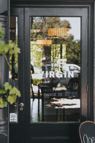 a door to a restaurant with a reflection in the window at Hotel Bellinzona Daylesford in Hepburn Springs
